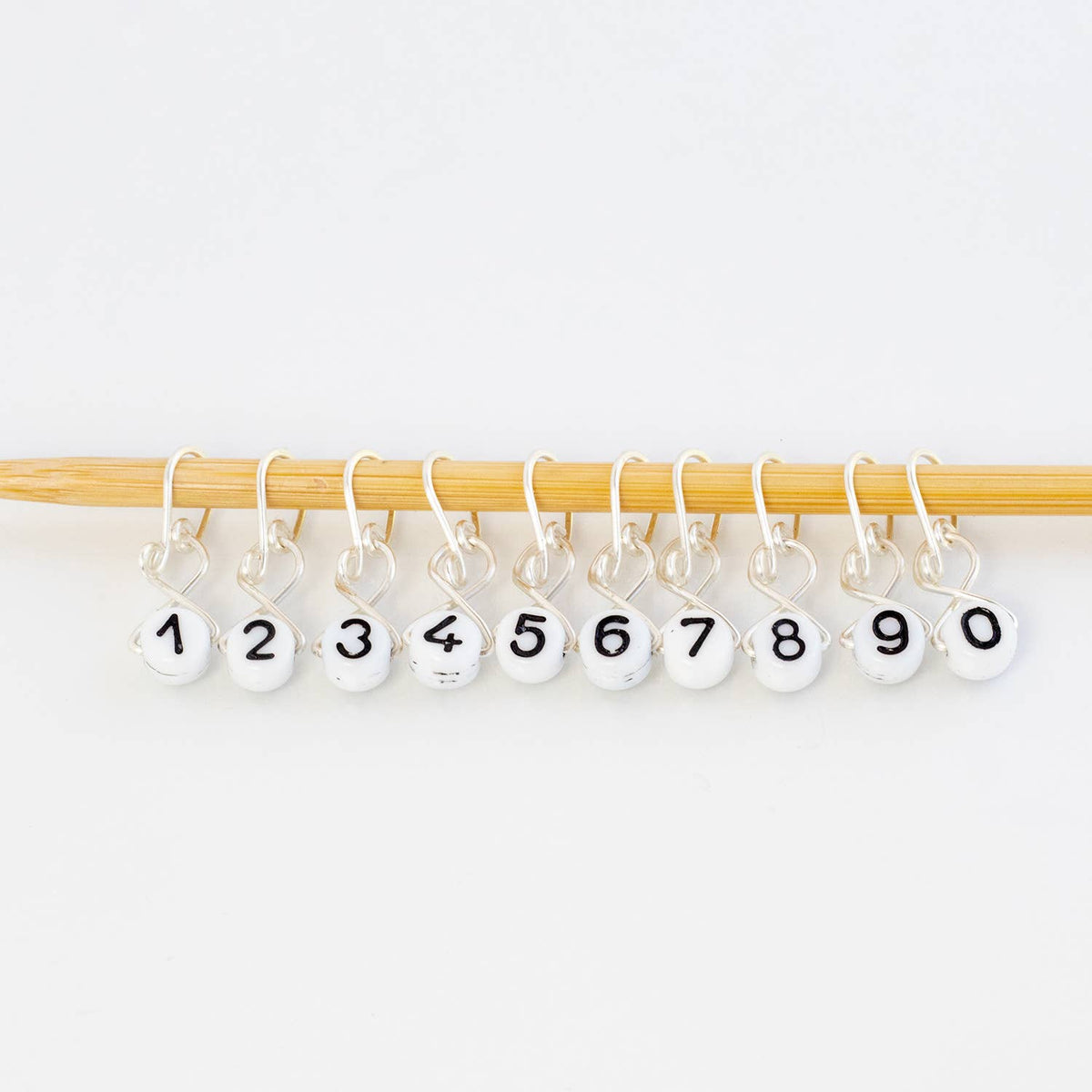 Number stitch markers on bamboo knitting needle